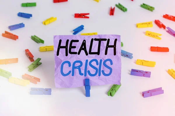 Writing note showing Health Crisis. Business photo showcasing fitness problem that affects in more geographic areas Colored clothespin papers empty reminder white floor background office.