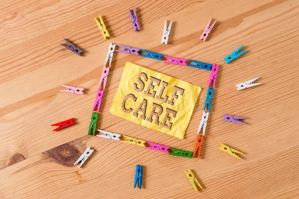 Schreiben Notiz zeigt Self Care. Geschäftliches Foto, das die Praxis zeigt, Maßnahmen zu ergreifen, um die eigene Gesundheit zu erhalten oder zu verbessern Farbige Wäscheklammern Papier leer Erinnerung Holzboden Hintergrundbüro. — Stockfoto