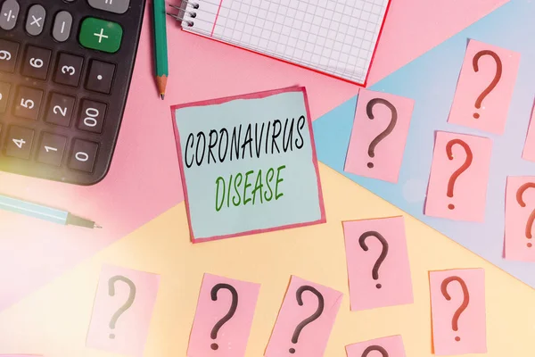 Coronavirus hastalığını gösteren kavramsal el yazısı. İş fotoğrafı sergisi, yeni bir virüs olan SARSCoV2 'nin sebep olduğu hastalık olarak tanımlanıyor. Matematik malzemeleri ve pastel arka plan üzerine yazma ekipmanları..