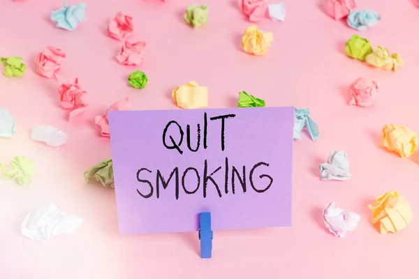 Kézírás szöveg írás leszokni a dohányzásról. Fogalom jelentése a folyamat abbahagyása vagy abbahagyása dohányzás Színes gyűrött papírok üres emlékeztető rózsaszín padló háttér ruhaszárító. — Stock Fotó
