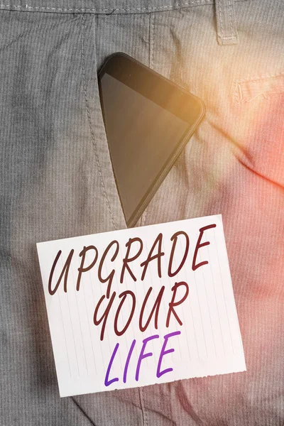 A Upgrade Your Life-ot bemutató jegyzet. Üzleti fotó bemutatása javítja az életmód egyre gazdagabb és boldogabb Okostelefon készülék belsejében nadrág első zseb jegyzet papír. — Stock Fotó