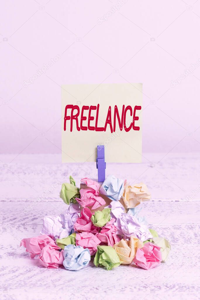 Word writing text Freelance. Business concept for working at different firms rather than being permanently Reminder pile colored crumpled paper clothespin reminder white wooden space.
