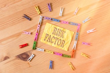 Risk faktörünü gösteren bir not yazıyorum. Bir hastalık kapma yüzdesini artırabilecek iş fotoğrafı gösterme özelliği Renkli çamaşır iğnesi kağıtları boş hatırlatıcı ahşap zemin arka planı