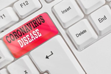 Coronavirus hastalığını gösteren kavramsal el yazısı. Yeni bir virüs olan SARSCoV2 beyaz pc klavyesinden kaynaklanan hastalık olarak tanımlanan iş fotoğrafı metni beyaz tuş alanının üzerinde boş not kağıdı ile.