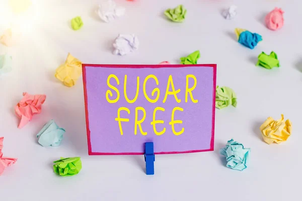 Написання нотатки, що показує Sugar Free. Відображення ділових фотографій не містить цукру і лише має штучний підсолоджувач замість кольорового збитого паперу порожнє нагадування про білий підлогу . — стокове фото