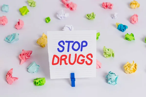 Λέξεις που γράφουν: Σταματήστε τα ναρκωτικά. Επιχειρησιακή ιδέα για να τεθεί τέλος στην εξάρτηση από ουσίες όπως η ηρωίνη ή η κοκαΐνη Έγχρωμα τσαλακωμένα χαρτιά κενό υπενθύμιση λευκό φόντο clothespin. — Φωτογραφία Αρχείου