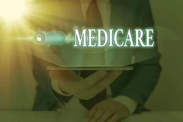Handwriting text Medicare. Concept meaning a policy of the federal government providing health care coverage Graphics padlock for web data information security application system.