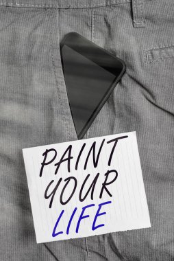 Hayatını Boya 'yı gösteren bir not yazıyorum. İş fotoğrafı gösterimi. Kontrolü ele almak ve hedeflere ulaşmak için geleceğinizi yaratmak. Pantolonun içinde akıllı telefon aygıtı..