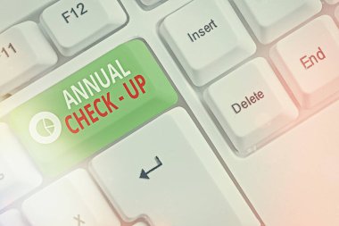 Yıllık kontrolleri yazan el yazısı metinleri. Bir sağlık hizmeti sağlayıcısına yıllık üreme sağlığı ziyareti anlamına gelen kavram boş fotokopi alanına aksesuarlar yerleştirilmiş farklı renkli klavye anahtarı.