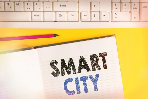 Texto de escritura de palabras Smart City. Concepto de negocio para un área urbana que utiliza tecnologías de comunicación para recopilar datos Copiar espacio en el cuaderno sobre fondo amarillo con teclado en la mesa . — Foto de Stock