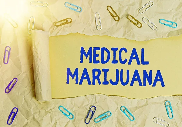 Writing note showing Medical Marijuana. Business photo showcasing available only by prescription and used to treat illness Rolled ripped torn cardboard above a wooden classic table.