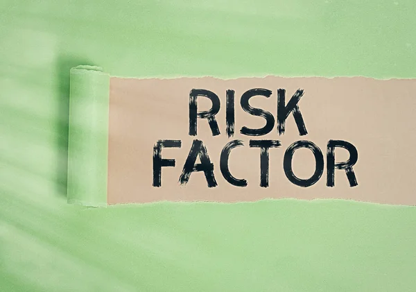 Text sign showing Risk Factor. Conceptual photo Characteristic that may increase the percentage of acquiring a disease Rolled ripped torn cardboard placed above a wooden classic table backdrop.