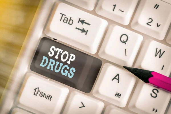Writing note showing Stop Drugs. Business photo showcasing put an end on the dependence on substances such as heroin or cocaine Colored keyboard key with accessories arranged on empty copy space.