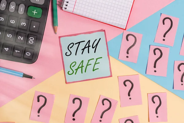 Conceptual hand writing showing Stay Safe. Business photo showcasing secure from threat of danger, harm or place to keep articles Mathematics stuff and writing equipment on pastel background.