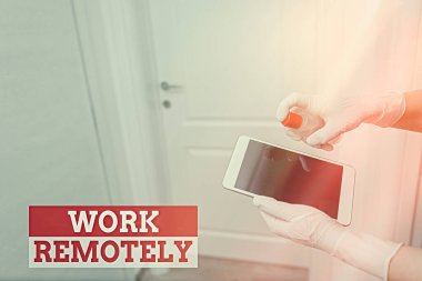 Kelime yazma metni uzaktan çalışıyor. Çalışanların, dezenfektanla kontrol edilen elektronik cihazlar içindeki kamu kirliliğinden uzakta işlerini yürüttükleri yeni iş anlayışı..