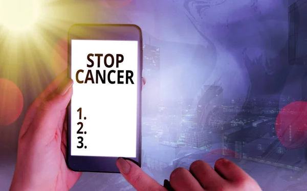 手書きのテキスト｜Stop Cancer。概念的な意味は、体内の異常な細胞の制御されていない成長を防ぐカラフルなボケの背景の下で白いディスプレイ画面を持つ現代のガジェット. — ストック写真