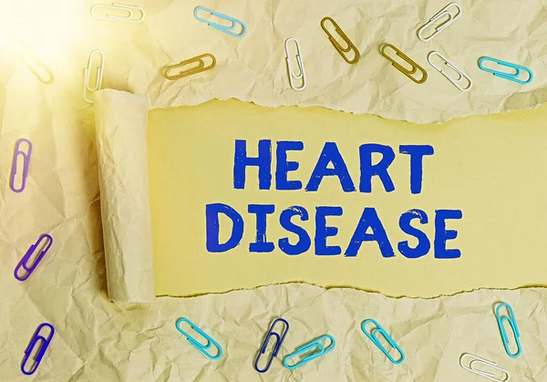 Writing note showing Heart Disease. Business photo showcasing A type of disease that affects the heart or blood vessels Rolled ripped torn cardboard above a wooden classic table. — Stock Photo, Image