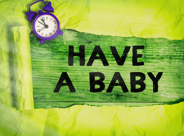 Tekst pisania słów "Have a baby". Koncepcja biznesowa dla rodziców spodziewają się lub będą mieli nowonarodzone dziecko Rolled rozdarty karton umieszczony nad drewnianym klasycznym tle tabeli. — Zdjęcie stockowe