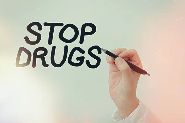 Handwriting text writing Stop Drugs. Concept meaning put an end on the dependence on substances such as heroin or cocaine Model displaying different shots of holding pen ready for promotional use.