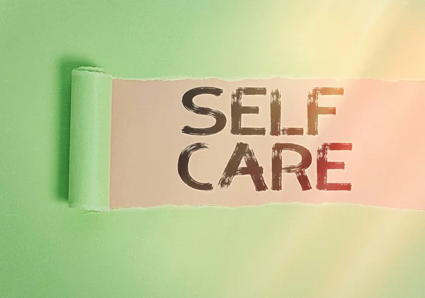 Text sign showing Self Care. Conceptual photo the practice of taking action to preserve or improve one s is health Rolled ripped torn cardboard placed above a wooden classic table backdrop. — Stock Photo, Image