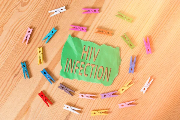 Word writing text Hiv Infection. Business concept for A disease of the immune system due to the infection of HIV Colored clothespin papers empty reminder wooden floor background office.