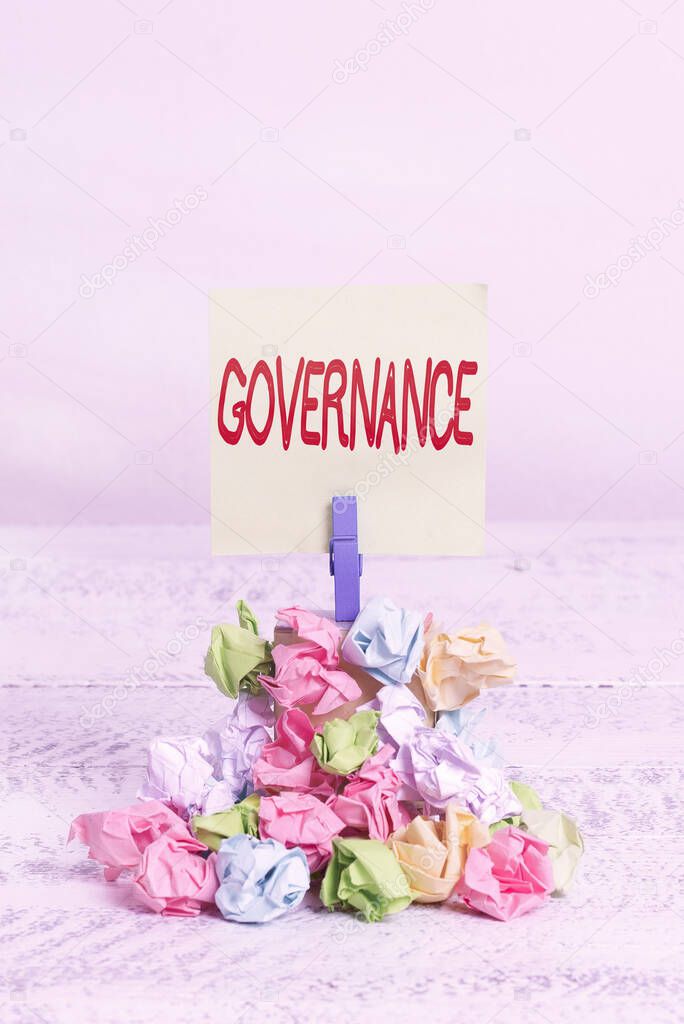 Word writing text Governance. Business concept for exercised in handling an economic situation in a nation Reminder pile colored crumpled paper clothespin reminder white wooden space.