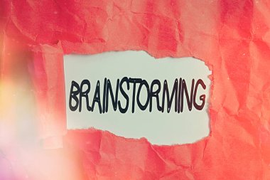 Beyin fırtınasını gösteren kavramsal el yazısı. Fikir ve çözümlere yol açan iş fotoğrafı grubu tartışması. Tahta klasik bir masanın üzerinde yırtık karton rulo..