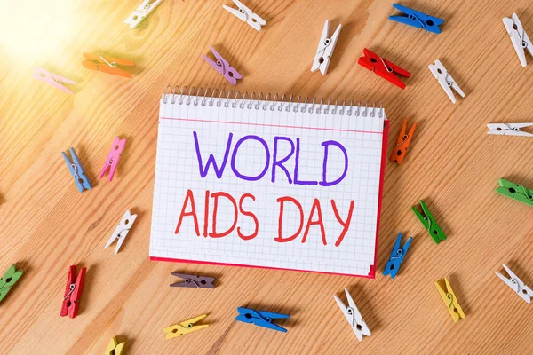 Εννοιολογικό γράψιμο που δείχνει την Παγκόσμια Ημέρα του AIDS. Επιχειρηματική φωτογραφία κείμενο μια διεθνή ημέρα για την ευαισθητοποίηση της πανδημίας του AIDS Έγχρωμα τσαλακωμένα χαρτιά ξύλινο πάτωμα φόντο clothespin. — Φωτογραφία Αρχείου