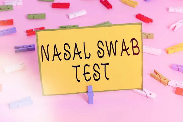 Word writing text Nasal Swab Test. Business concept for diagnosing an upper respiratory tract infection through nasal secretion Colored clothespin papers empty reminder pink floor background office