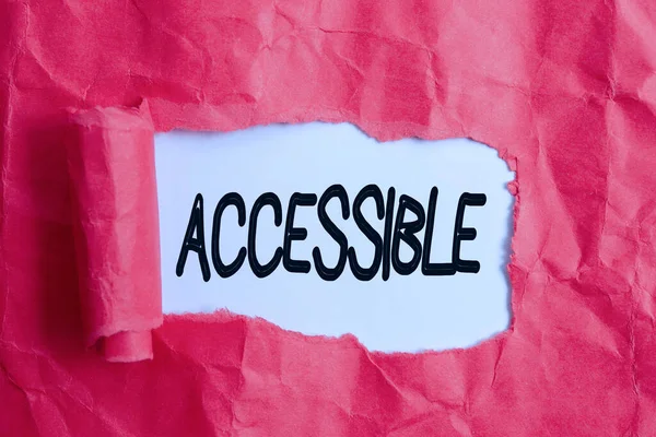 Conceptual hand writing showing Accessible. Business photo text defined as something you can get to use or obtain or reach Rolled ripped torn cardboard above a wooden classic table. — Stock Photo, Image