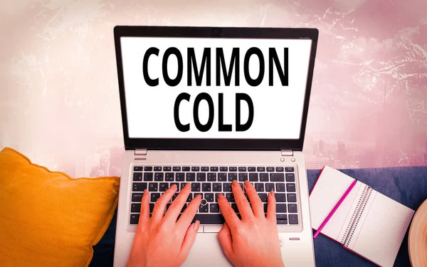 Conceptual hand writing showing Common Cold. Business photo text viral infection in upper respiratory tract primarily affecting nose Modern gadgets white screen under colorful bokeh background.