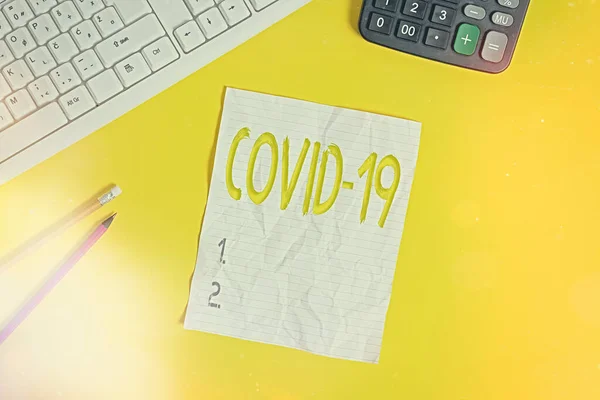 Nota de redação mostrando Covid19. Foto de negócios mostrando doença respiratória leve a grave que é causada por um coronavírus Copiar espaço no notebook acima fundo amarelo com teclado na mesa . — Fotografia de Stock