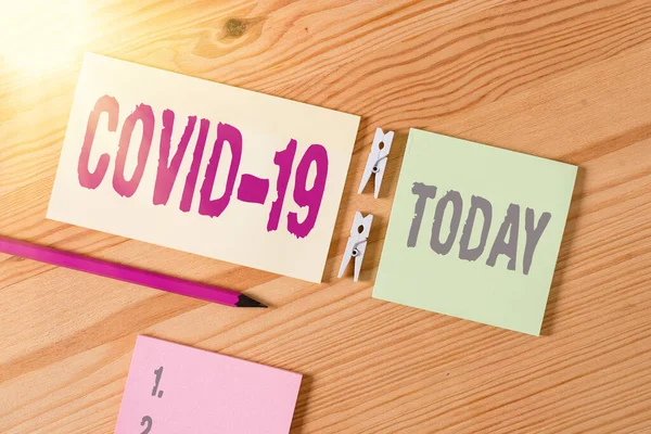 Conceptual hand writing showing Covid19. Business photo text mild to severe respiratory illness that is caused by a coronavirus Colored crumpled papers wooden floor background clothespin. — Stock Photo, Image