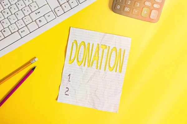 Writing note showing Donation. Business photo showcasing something that is given to a charity, especially a sum of money Copy space on notebook above yellow background with keyboard on table.