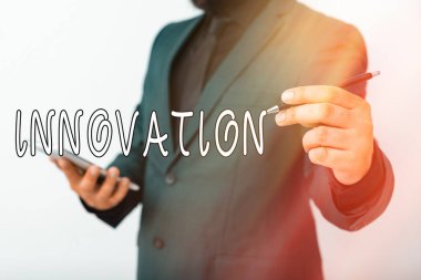 El yazısı metni Yenilik. Kavram, yeni yaratıcı fikirler anlamına gelir. Alet biçimi sürecinde yeni hayaller. Model, kalemi promosyon amaçlı kullanıma hazır tutmanın farklı çekimlerini gösterir..