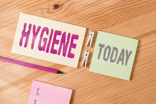 Conceptueel handschrift met Hygiëne. Business foto tekst studie van de wetenschap van de oprichting en het onderhoud van de gezondheid Gekleurde verkreukelde papieren houten vloer achtergrond wasknijper. — Stockfoto