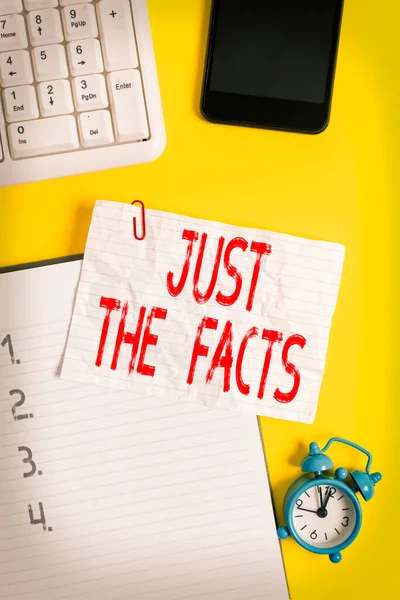 Tulisan tangan Just The Facts. Konsep makna untuk memiliki informasi yang benar tentang rincian yang tepat Kertas putih kusut di atas meja dengan klip kertas jam mobile dan papan ketik pc. — Stok Foto