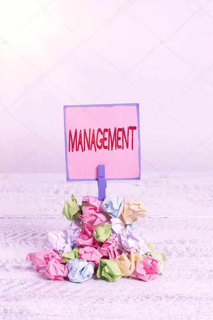 Text sign showing Management. Conceptual photo the authoritative act of directing or controlling things Reminder pile colored crumpled paper clothespin reminder white wooden space.