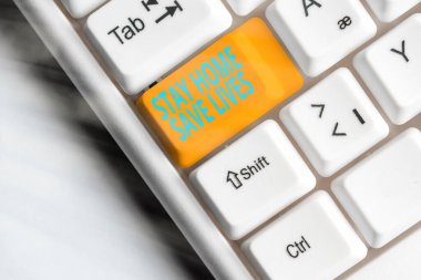 Mesaj işareti Evde Kalın Hayatları Kurtarın 'ı gösteriyor. Kavramsal fotoğraf, evi terk etmeyerek hastalıklı hasta sayısını azaltır. Boş kopya alanındaki aksesuarlarla farklı renklerde klavye anahtarı.