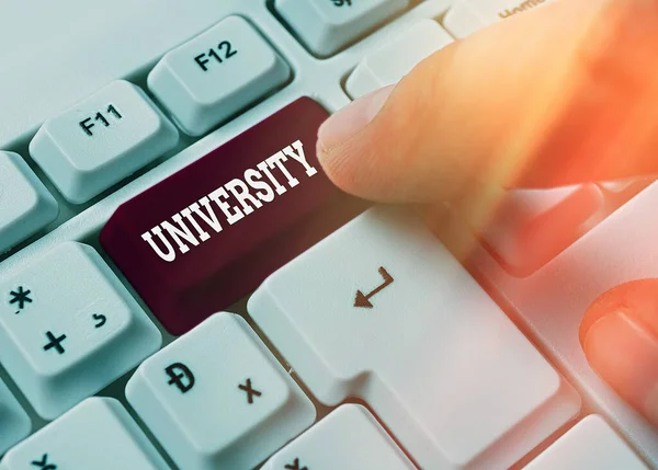 Writing note showing University. Business photo showcasing an educational institution designed to teach and investigate White pc keyboard with empty note paper above white key copy space. — Stock Photo, Image