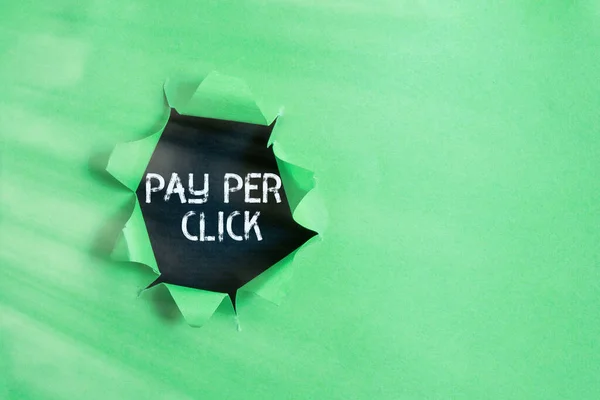 Schrijfbriefje met Pay Per Click. Zakelijke foto presentatie internet marketing waarin de betaling is gebaseerd op clickthrough Gewalst gescheurd karton boven een houten klassieke tafel. — Stockfoto