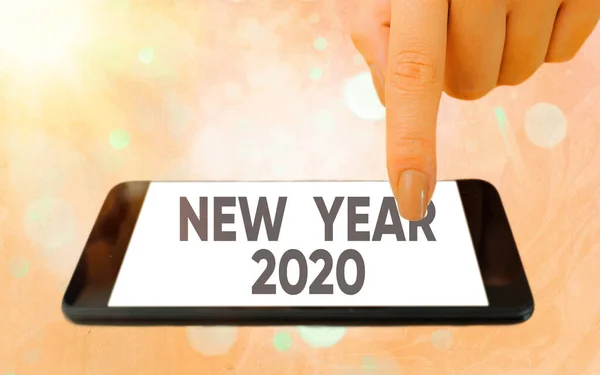 Κείμενο που δείχνει το νέο έτος 2020. Έννοια φωτογραφία Χαιρετισμός Γιορτάζοντας Διακοπές Fresh Start Καλύτερες ευχές Σύγχρονα gadgets με λευκή οθόνη προβολής κάτω από πολύχρωμο φόντο bokeh. — Φωτογραφία Αρχείου