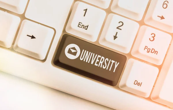 Word writing text University. Business concept for an educational institution designed to teach and investigate Different colored keyboard key with accessories arranged on empty copy space. — Stock Photo, Image