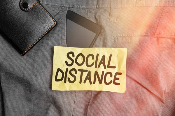 Writing note showing Social Distance. Business photo showcasing maintaining a high interval physical distance for public health safety Smartphone device inside trousers front pocket with wallet.