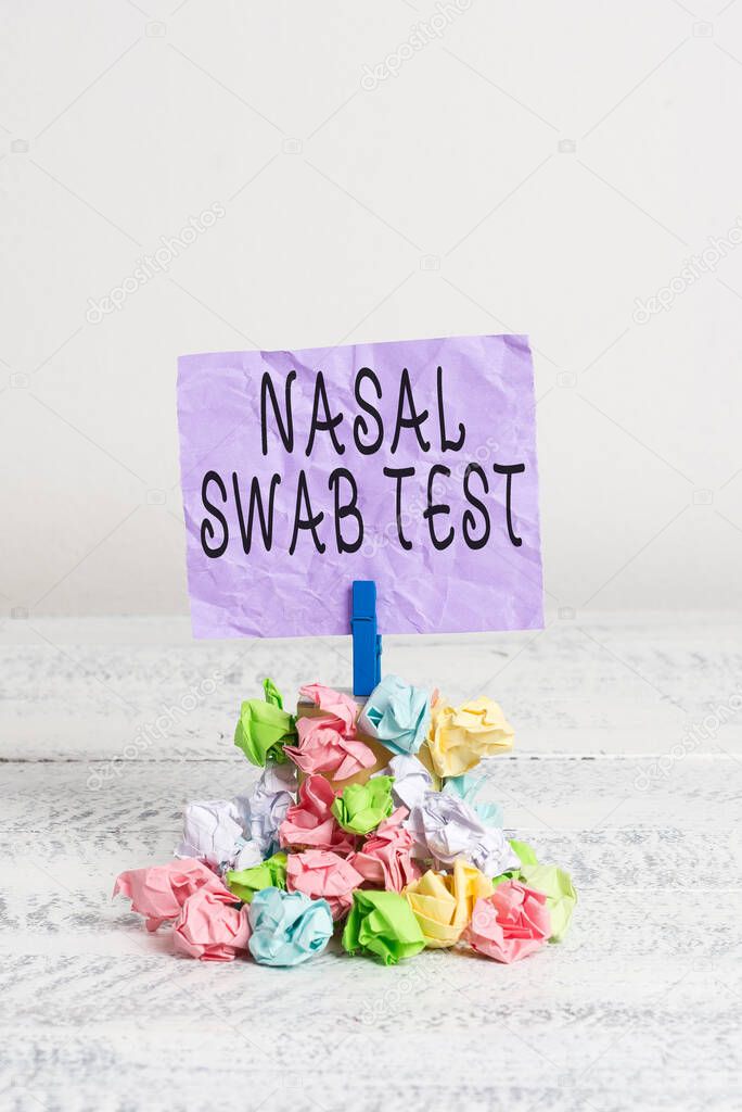 Writing note showing Nasal Swab Test. Business photo showcasing diagnosing an upper respiratory tract infection through nasal secretion Reminder pile colored crumpled paper clothespin wooden space.