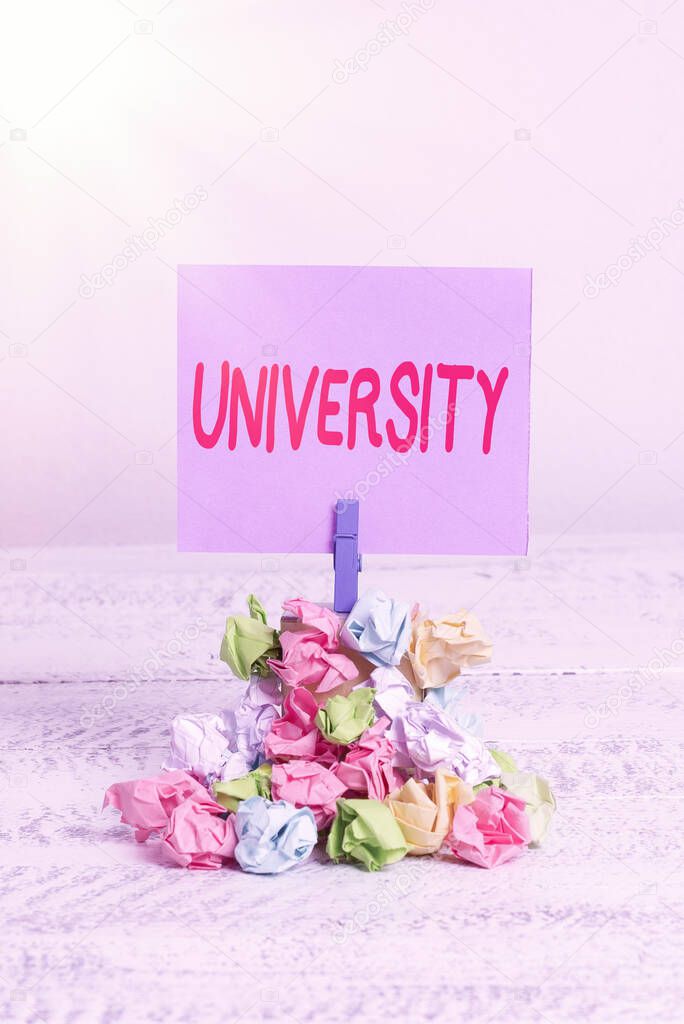 Word writing text University. Business concept for an educational institution designed to teach and investigate Reminder pile colored crumpled paper clothespin reminder white wooden space.