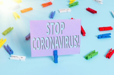 El yazısı Coronavirus 'u durdurun. Kavram derken, COVID19 vakalarını azaltmak için mücadele eden Hastalık Bilinci kampanyası Renkli çamaşır iğnesi kağıtları boş mavi zemin ofis broşu.