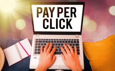 Klik başına ödeme gösteren kavramsal el yazısı. İş fotoğraflarında internet pazarlaması gösteriliyor. Ödeme, renkli bokeh arka plan altında modern cihazlara dayalı..