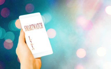 Smartwatch 'ı gösteren kavramsal el yazısı. Bir bileğe takılacak dokunmatik ekranlı mobil arayüzü gösteren iş fotoğrafı renkli bokeh arkaplan altında modern cihazlar beyaz ekran.