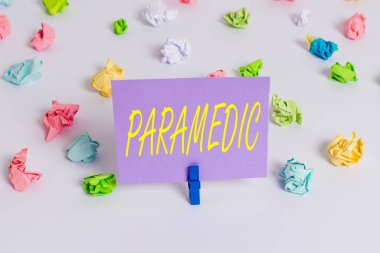 Paramediklerin el yazısı. Konsept, acil tıbbi işlerde uzman bir sağlık çalışanı anlamına gelir. Kırışmış kağıtlar boş hatırlatıcı beyaz zemin çamaşır mandalı..